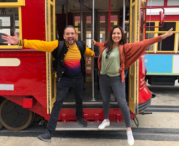 A young latin female and a young latin male, traveling around New Orleans by cablecars - stock photo
