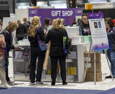 The image depicts a busy moment at the Gift Shop during the Magnet/Pathway Conference. 